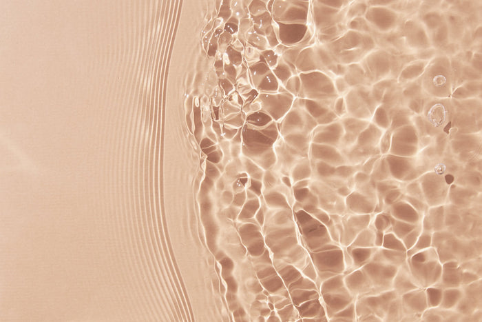 Rippling water surface with a pink tint